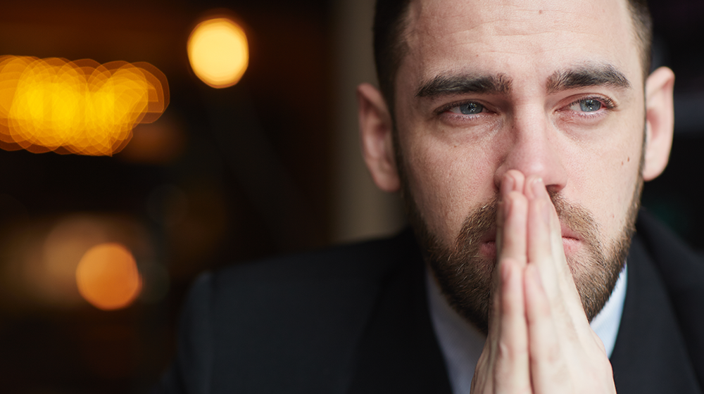 Mann schaut grübelnd in eine ungewisse Zukunft